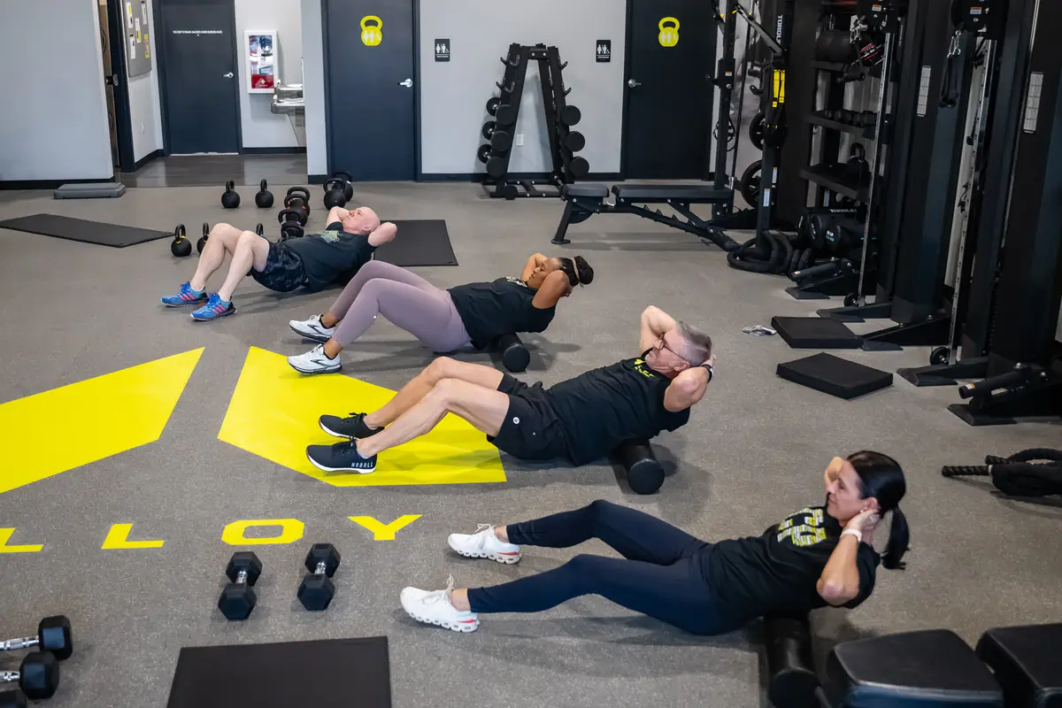 A coached small group core and mobility session on the Alloy studio floor